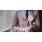 A man in a formal suit adjusting the cuffs of his shirt