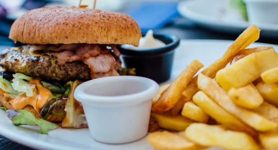 Double cheeseburger and a side of french fries at a restaurant