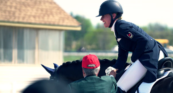 A woman equestrian rider sitting on her horse, talking to her coach in Ottawa