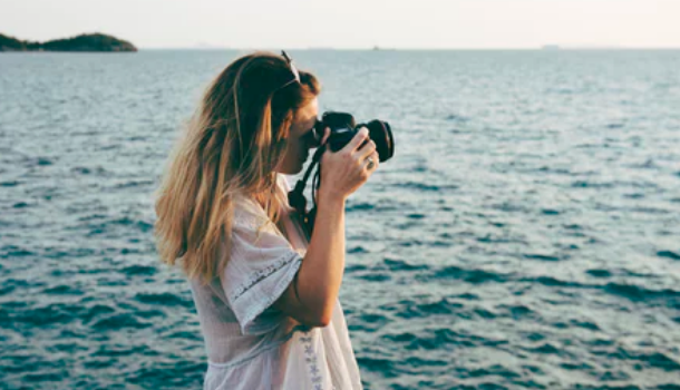 A woman photographing the ocean