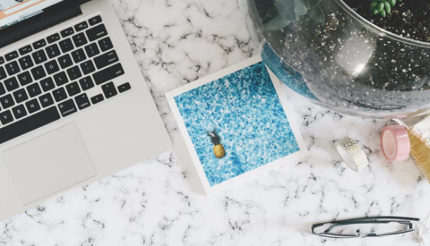 A Macbook and other items on top of a marble 